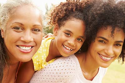 grandmother, mother, and daughter smiling together