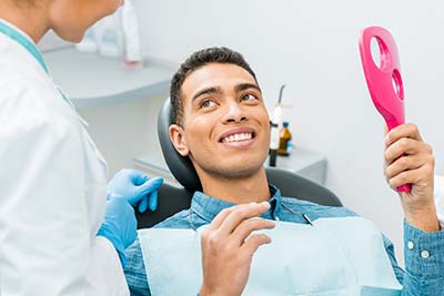 man talking with a dentist about getting a smile makeover